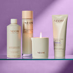 NEOM skincare products including bath foam, lotion, and candle on a purple background