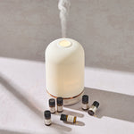 NEOM pod diffuser and essential oil discovery set on a white background