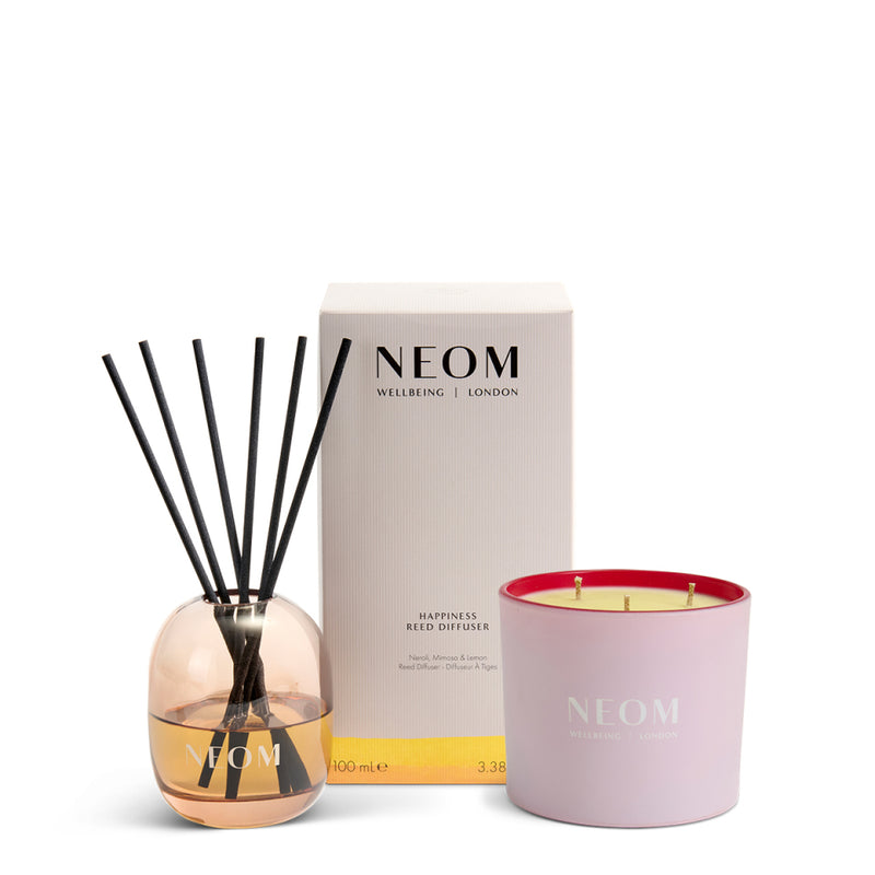 NEOM happiness reed diffuser and It's All Rosy travel candle on a white background