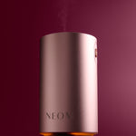 NEOM diffuser emitting steam on a dark background