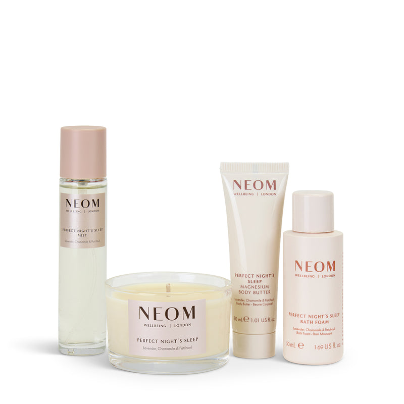 NEOM Sleep products including a candle, bath foam, body butter and pillow mist on a white background