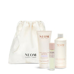 NEOM skincare products including a drawstring bag on a white background