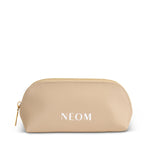 Gold cosmetic bag with 'NEOM' branding on a white background